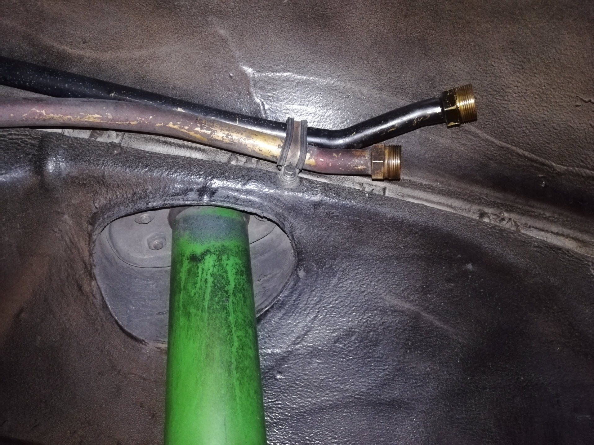Air-cooled Porsche 911 hard oil line clamp above shock absorber.
