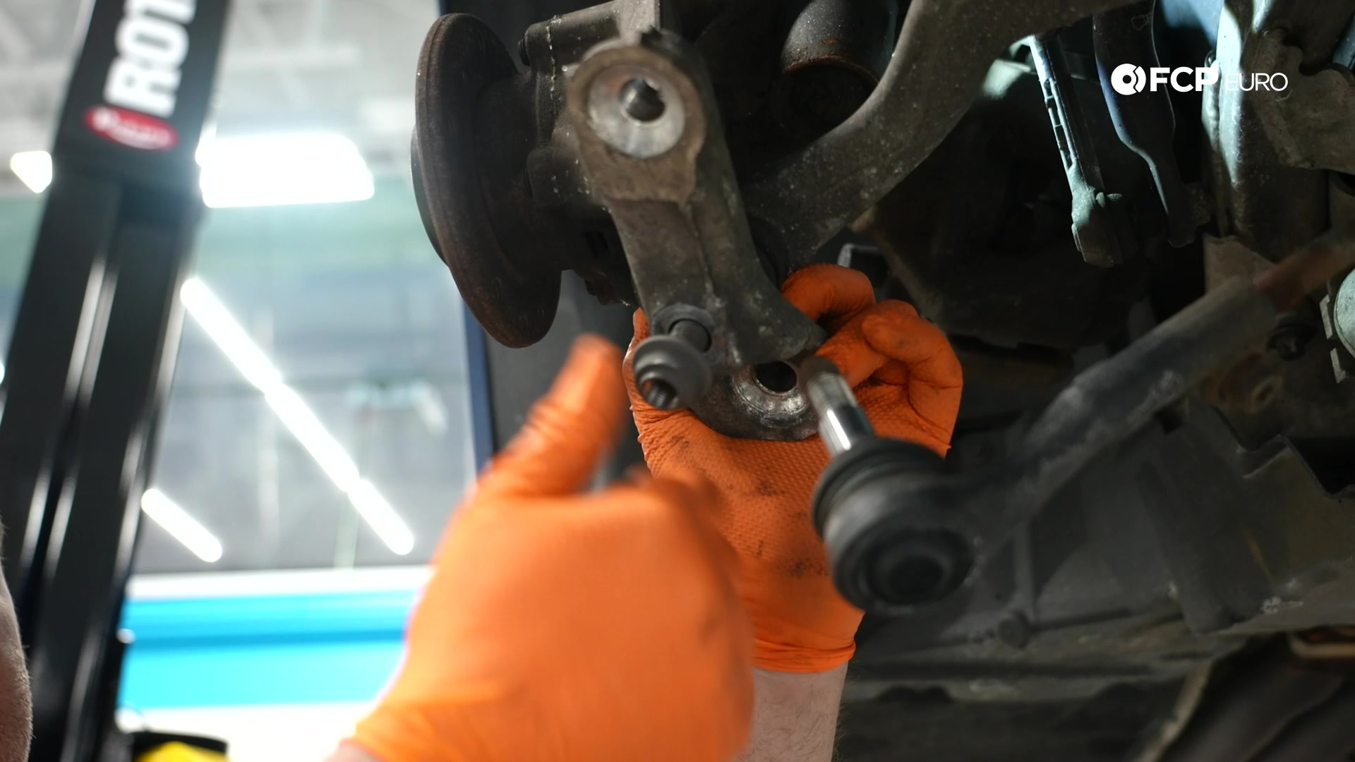 DIY BMW E90 Steering Knuckle Replacement supporting the knuckle with the thrust arm’s ball joint