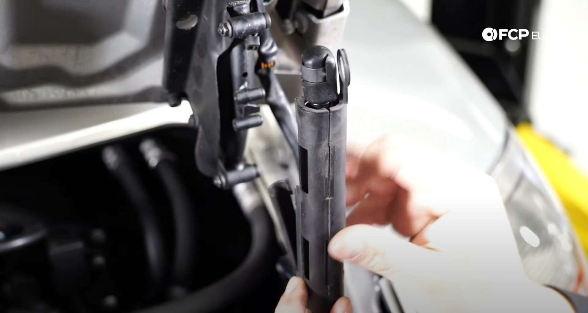 DIY Porsche 996 911 Hood and Engine Lid Strut Replacement placing the harness clip onto the new strut