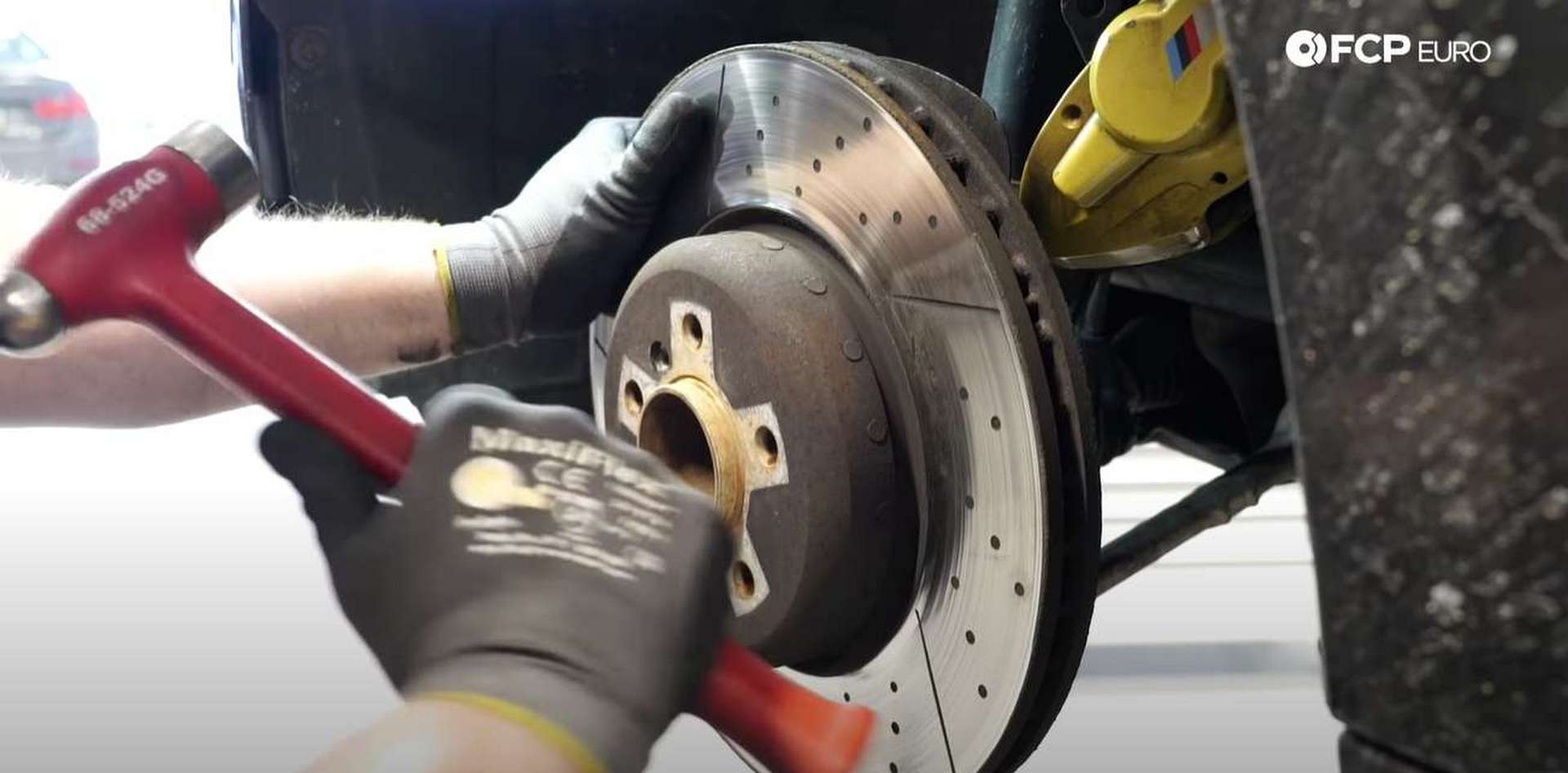 DIY BMW F30 M-Sport Brake Service hitting the rotor with a hammer to break the corrosion