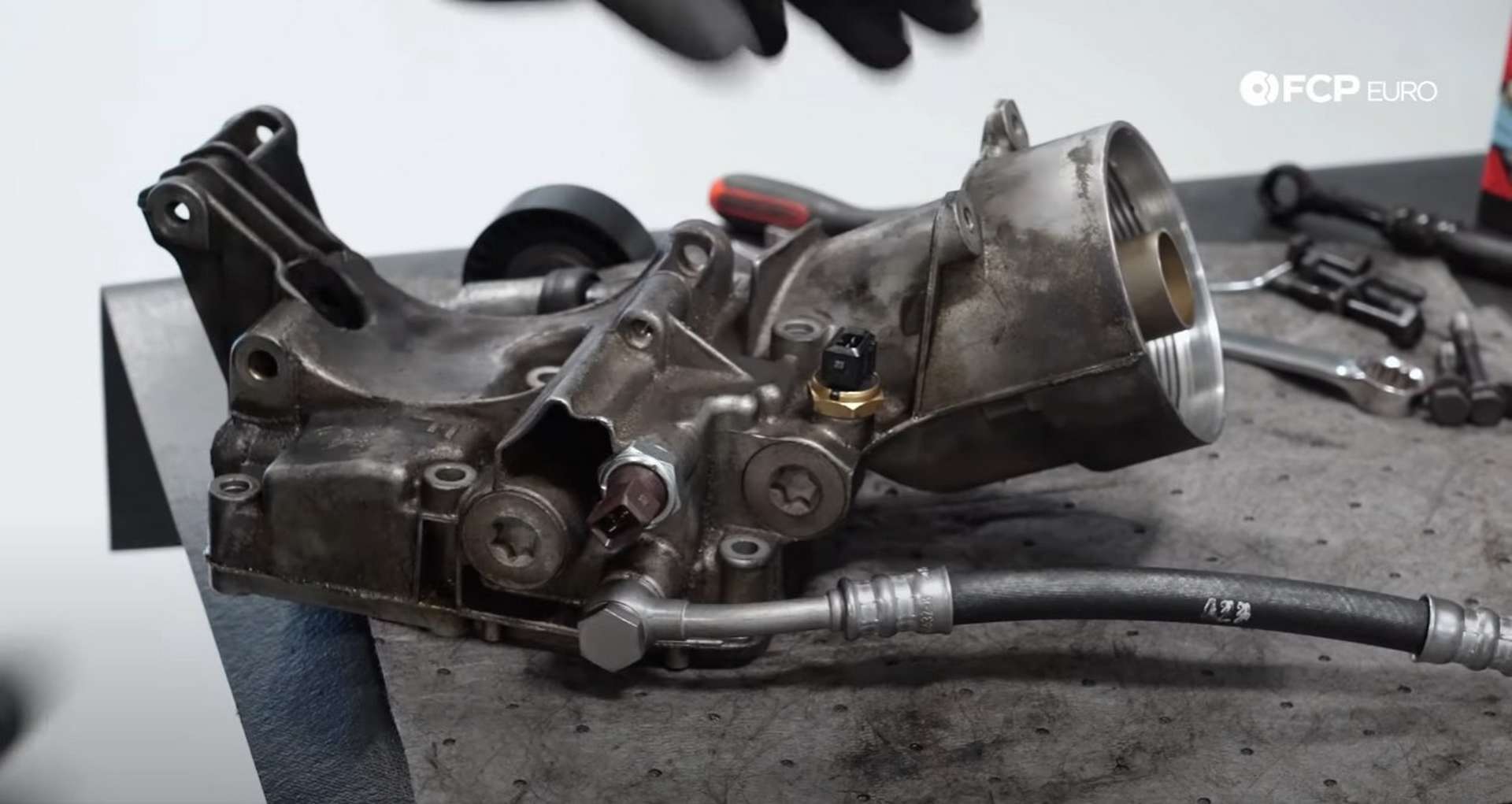 DIY BMW E46 Oil Filter Housing Gasket and VANOS Line Replacement installing the new VANOS line onto the housing]