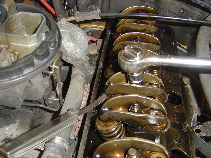 A valve lash adjustment being performed