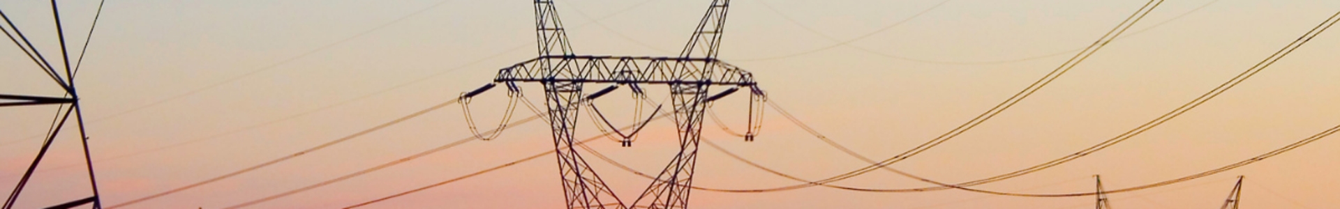 Electricity pylons at sunset distributing energy across the UK from renewable sources