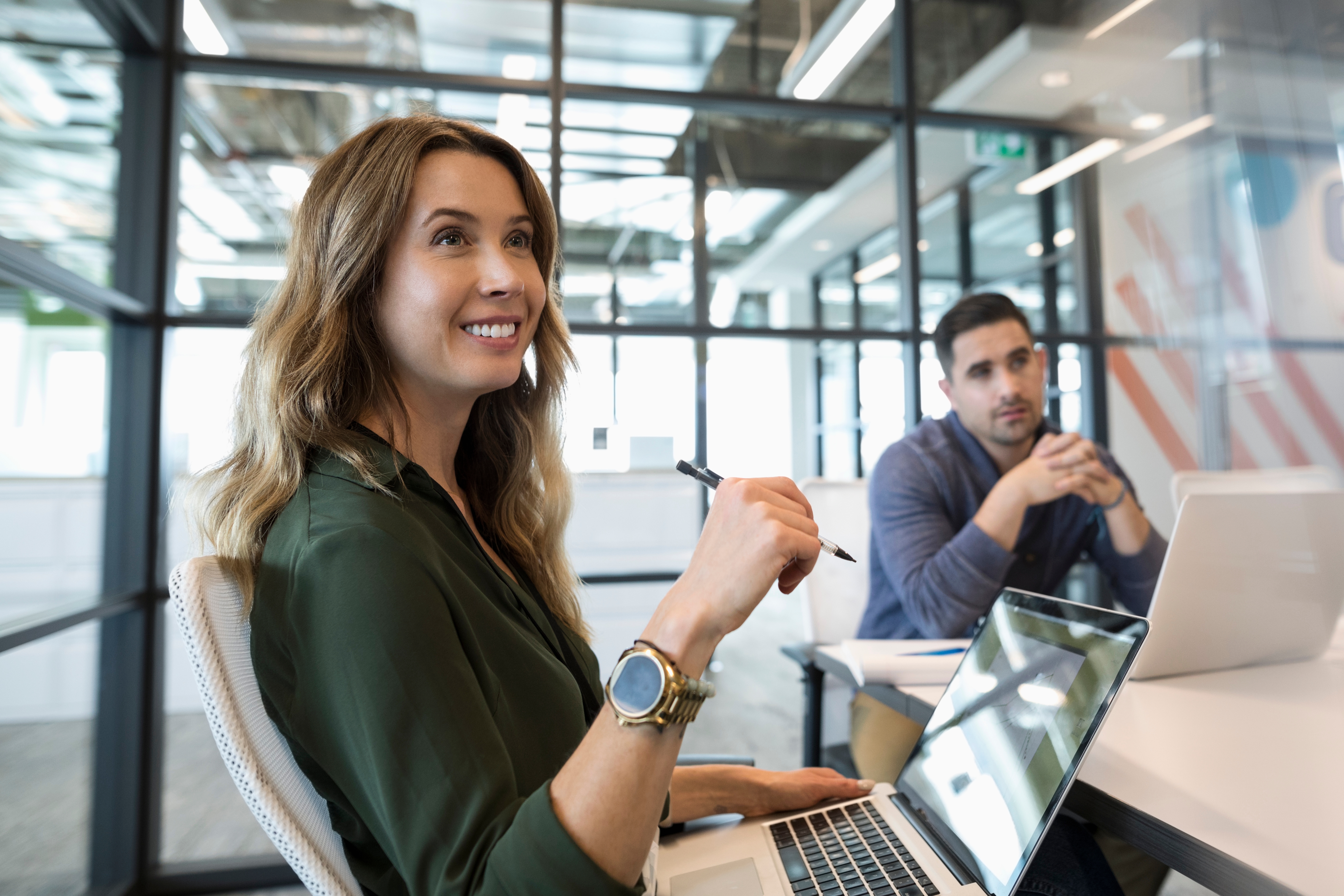 Woman sitting at a table smiling and making notes during an SLE preparation course with Berlitz Canada
