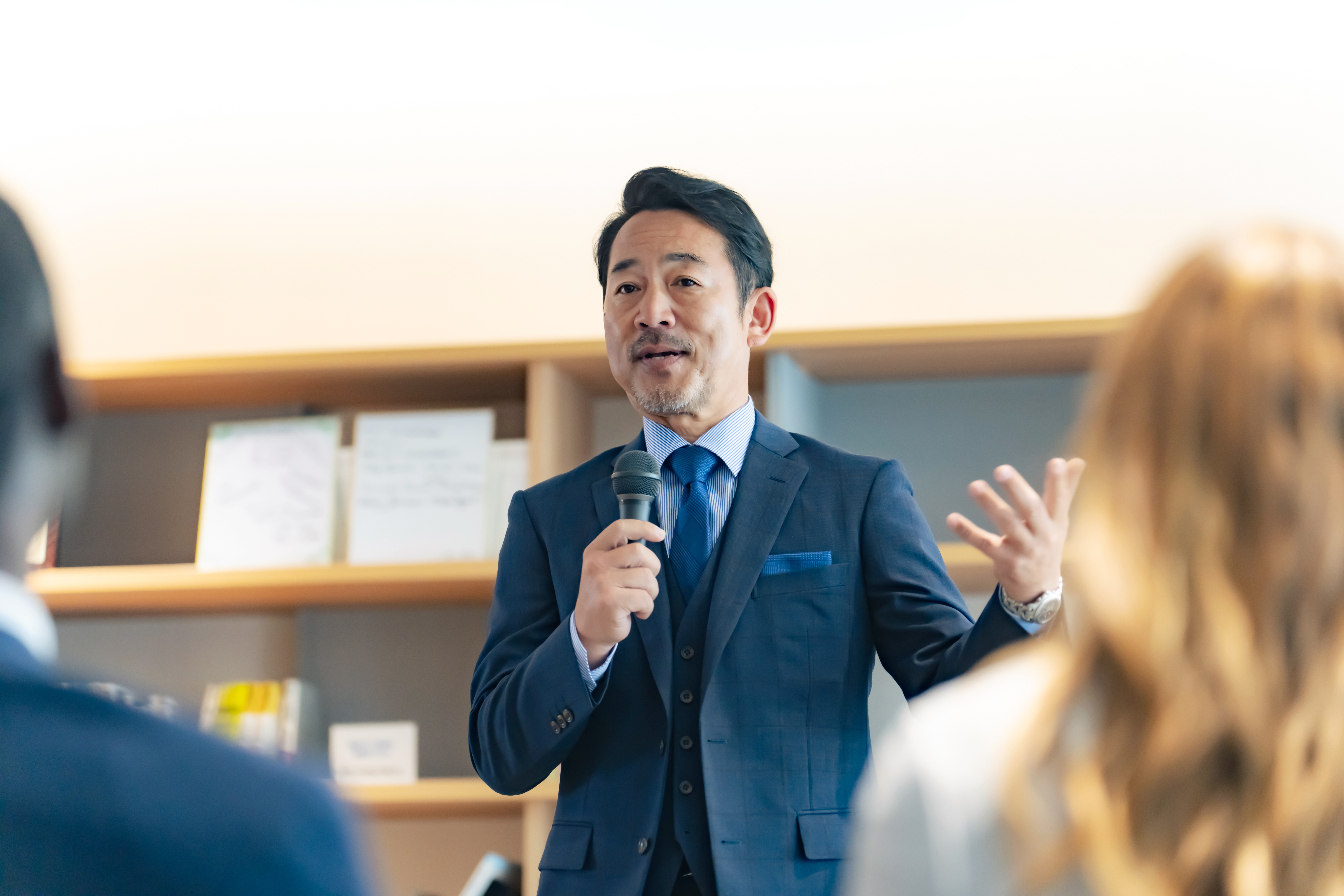 Man in a federal position holding a microphone and talking confidently in French