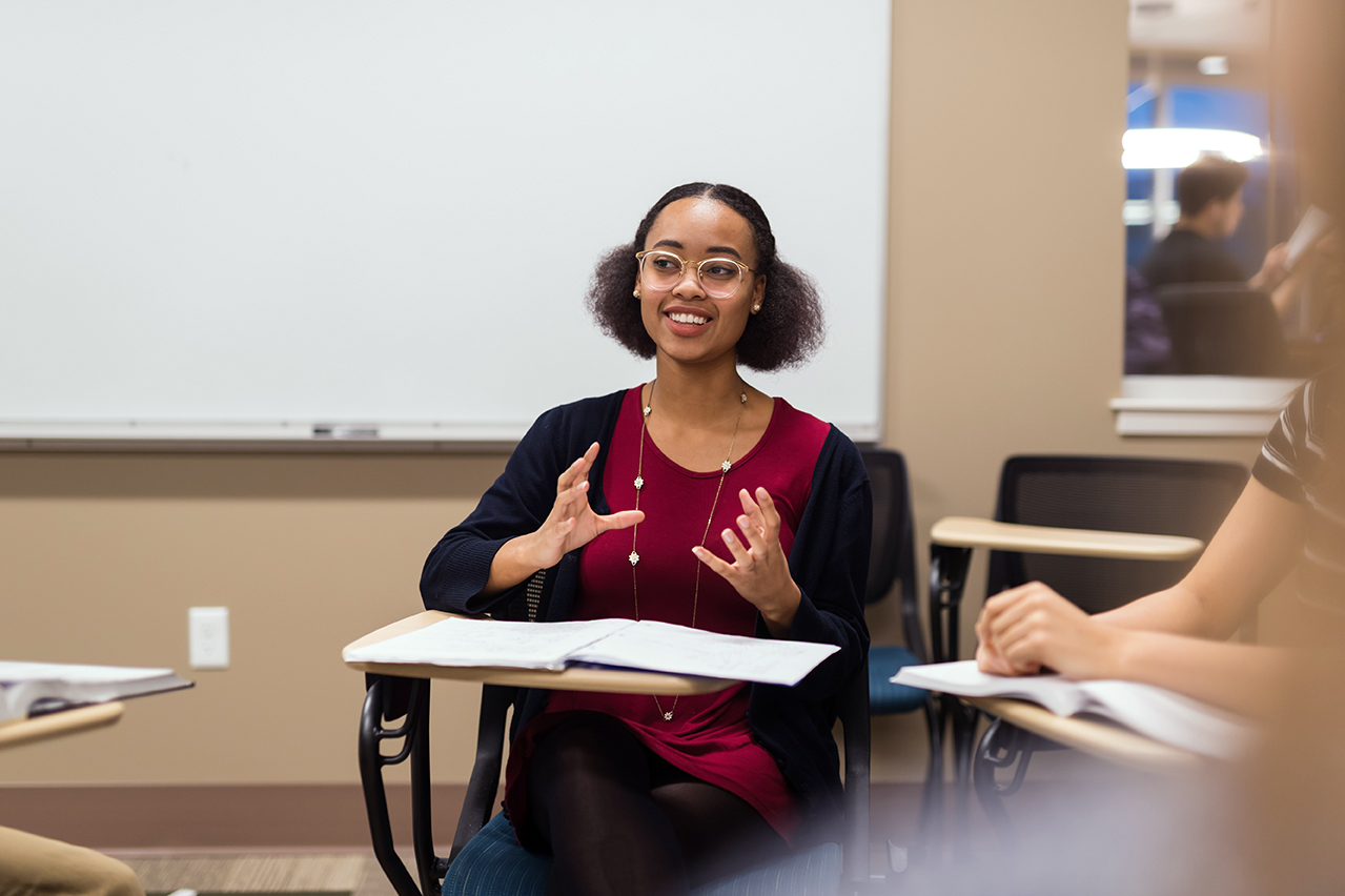 Woman in a classroom speaking in a foreign language during her Test of Oral Proficiency