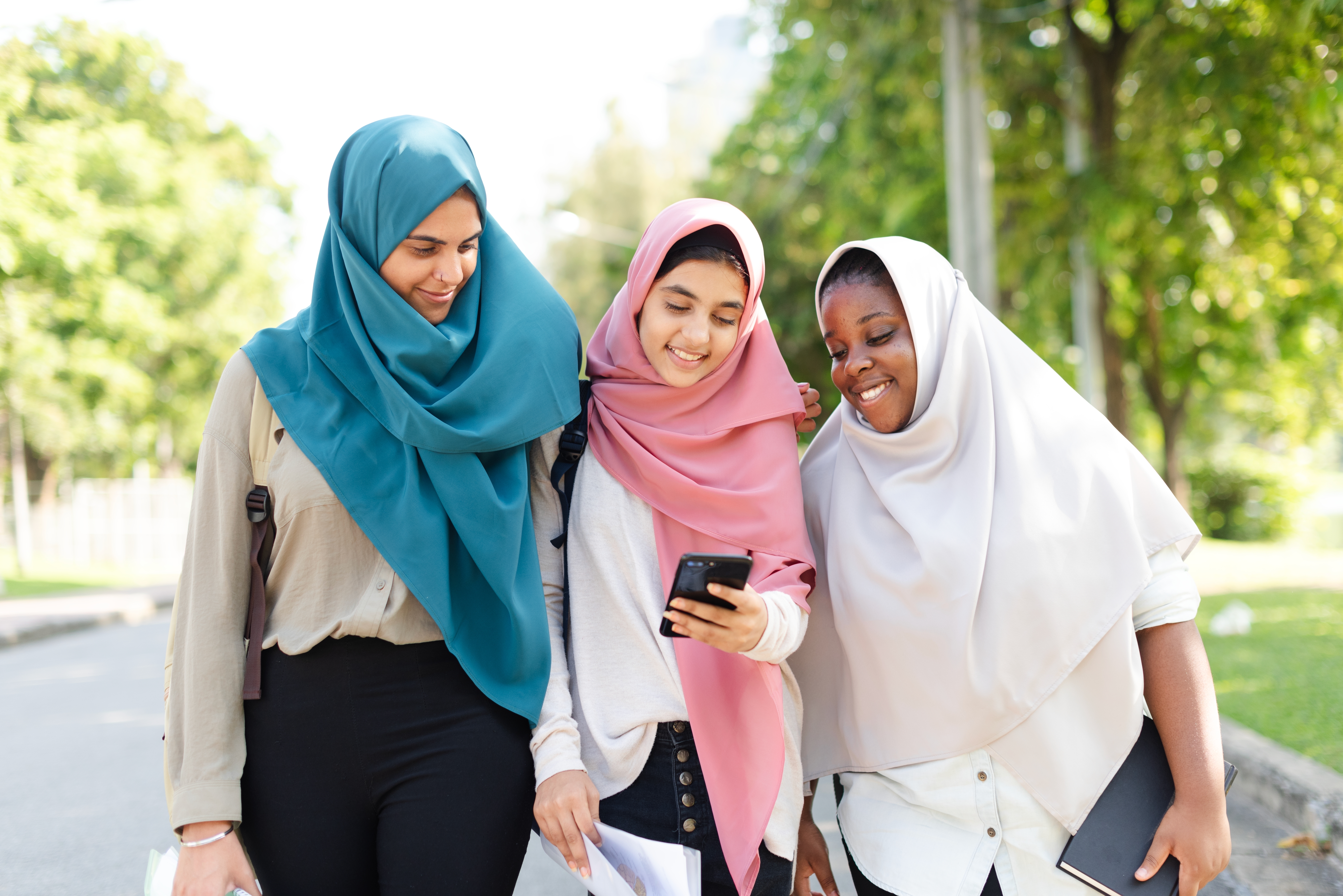 Group of girls looking at a phone together after their French lesson for kids and teens with Berlitz Canada
