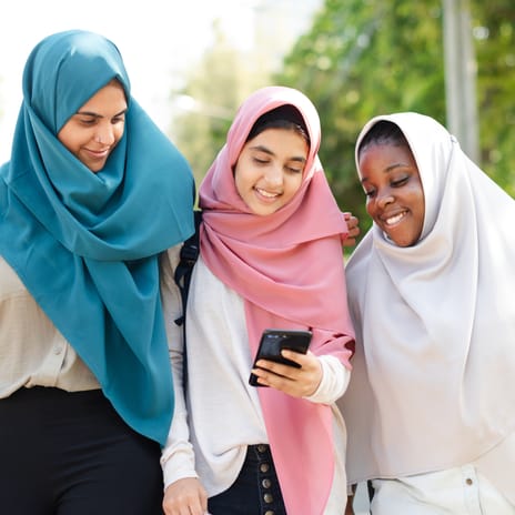 Group of girls looking at a phone together after their French lesson for kids and teens with Berlitz Canada