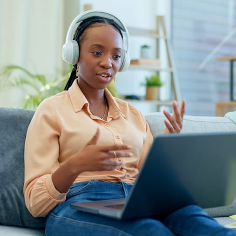 Woman with headphones talking to her instructor during an online TEF preparation course with Berlitz Edmonton