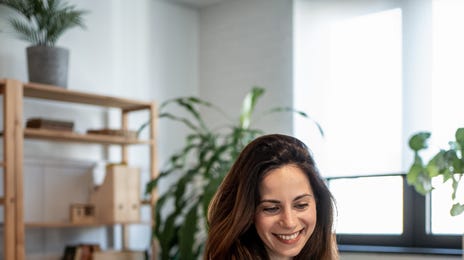 Woman making notes while attending a private online language lesson with Berlitz Canada