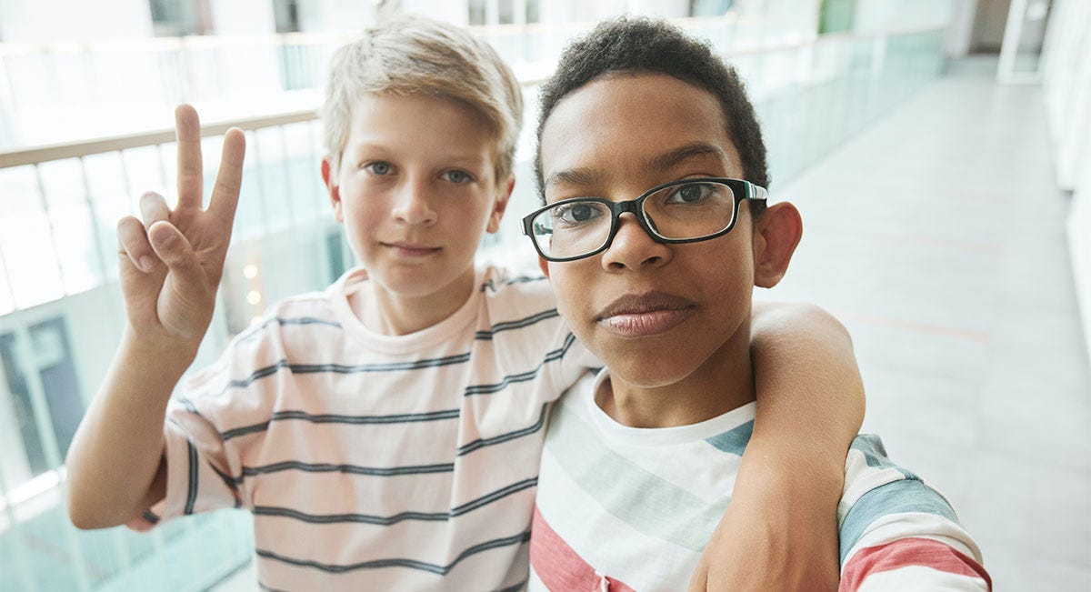 Two schoolboys hugging each other