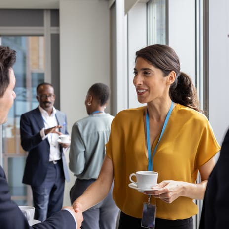Chief People Officer talking to employees during a conference.