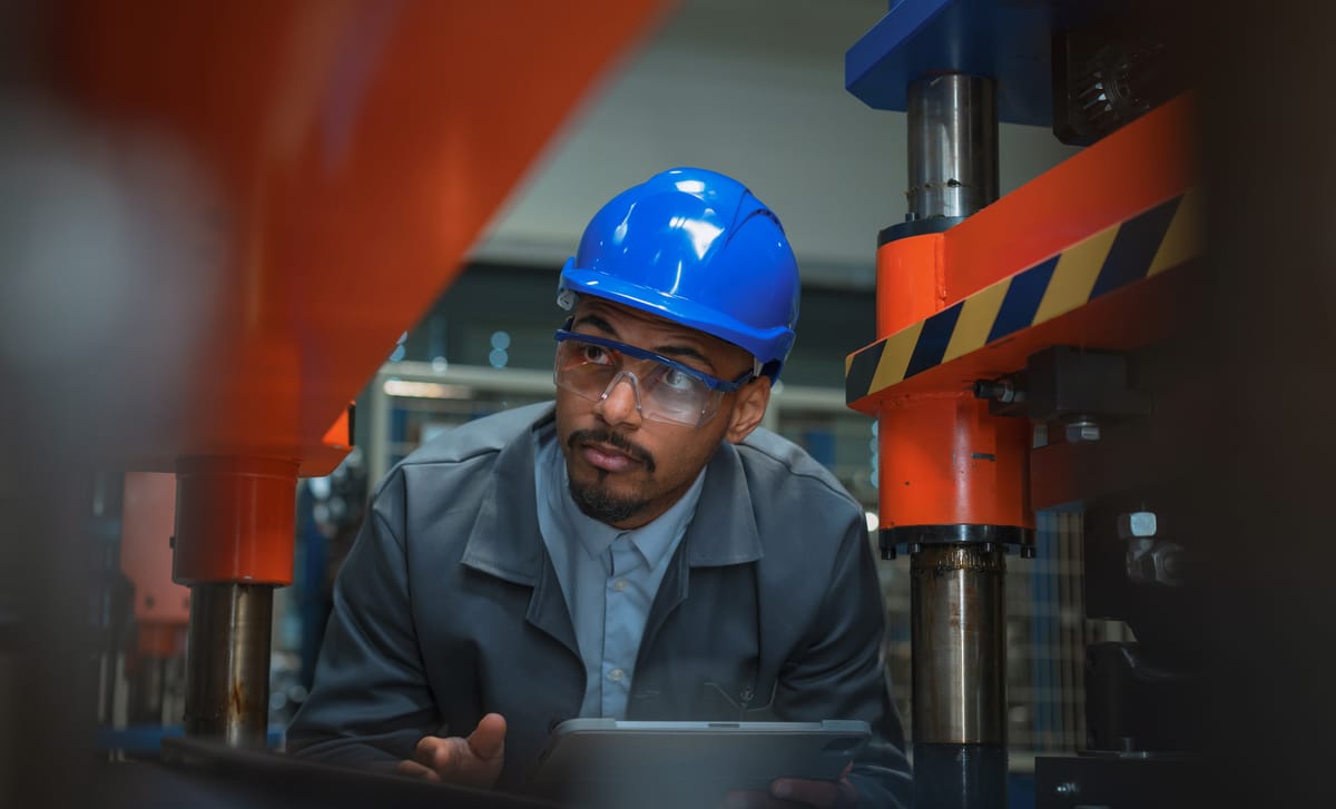 Man in a blue helmet looking at equipment after his construction language training with Berlitz Canada