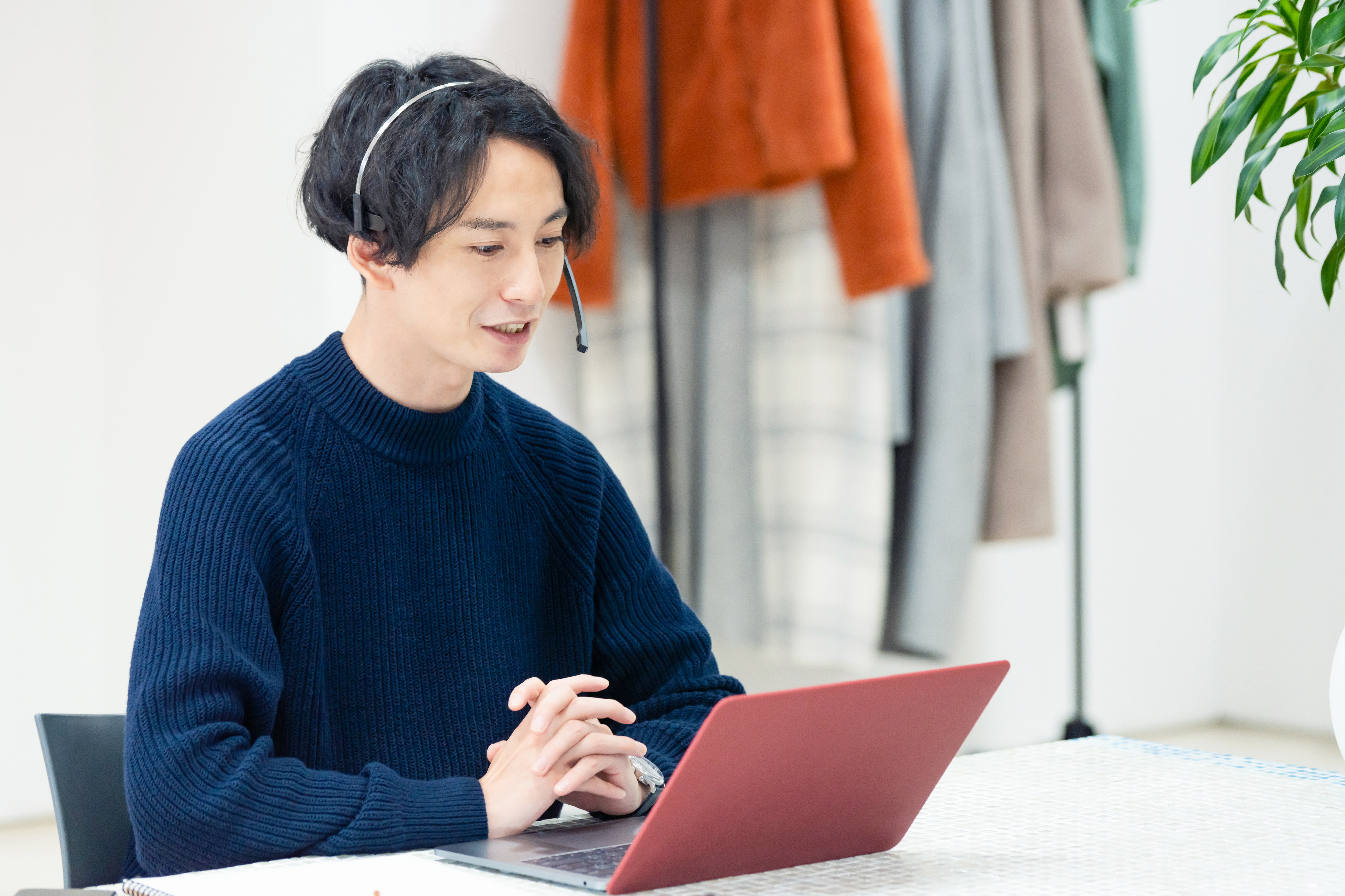 Man with headphones talking to his instructor during an online group language class with Berlitz that he is attending from his laptop