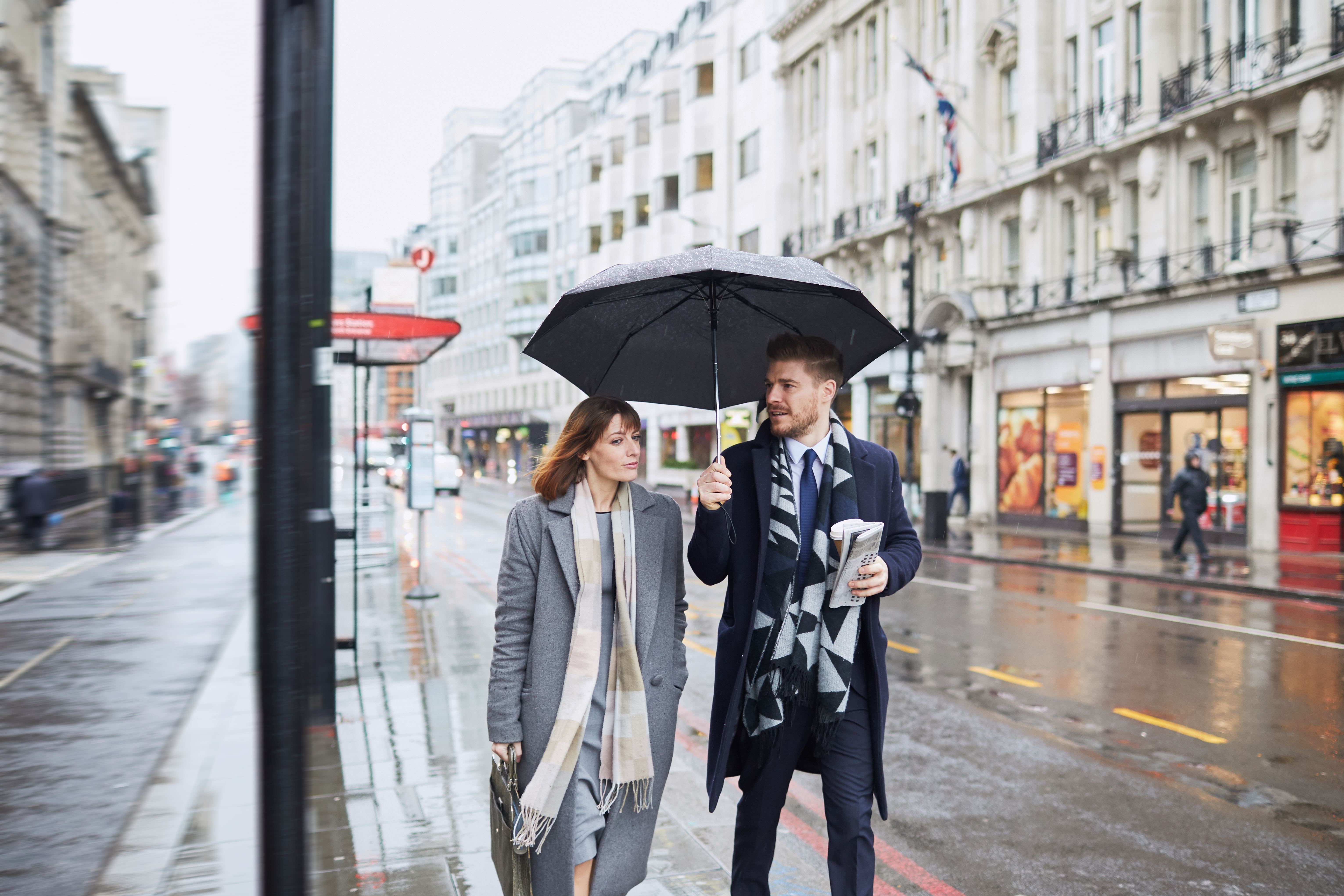 man and woman talking about their future carrier opportunities under an umbrella in the city