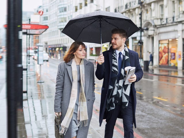 man and woman talking about their future carrier opportunities under an umbrella in the city