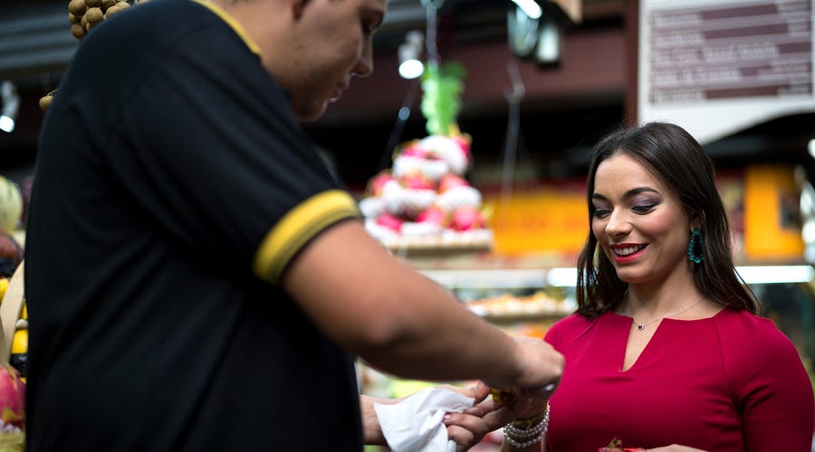 Woman talking to a seller in the market and saying yes