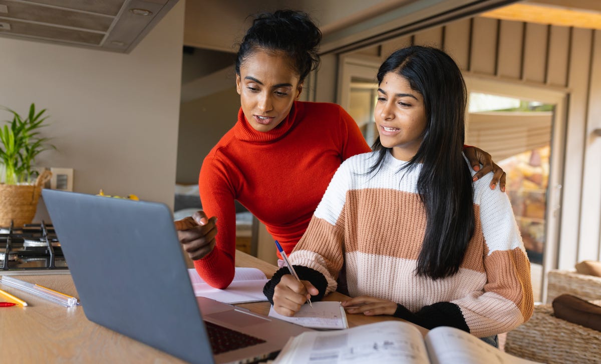 Woman and her instructor talking to each other while the student is making notes during an English lesson with Berlitz Ottawa
