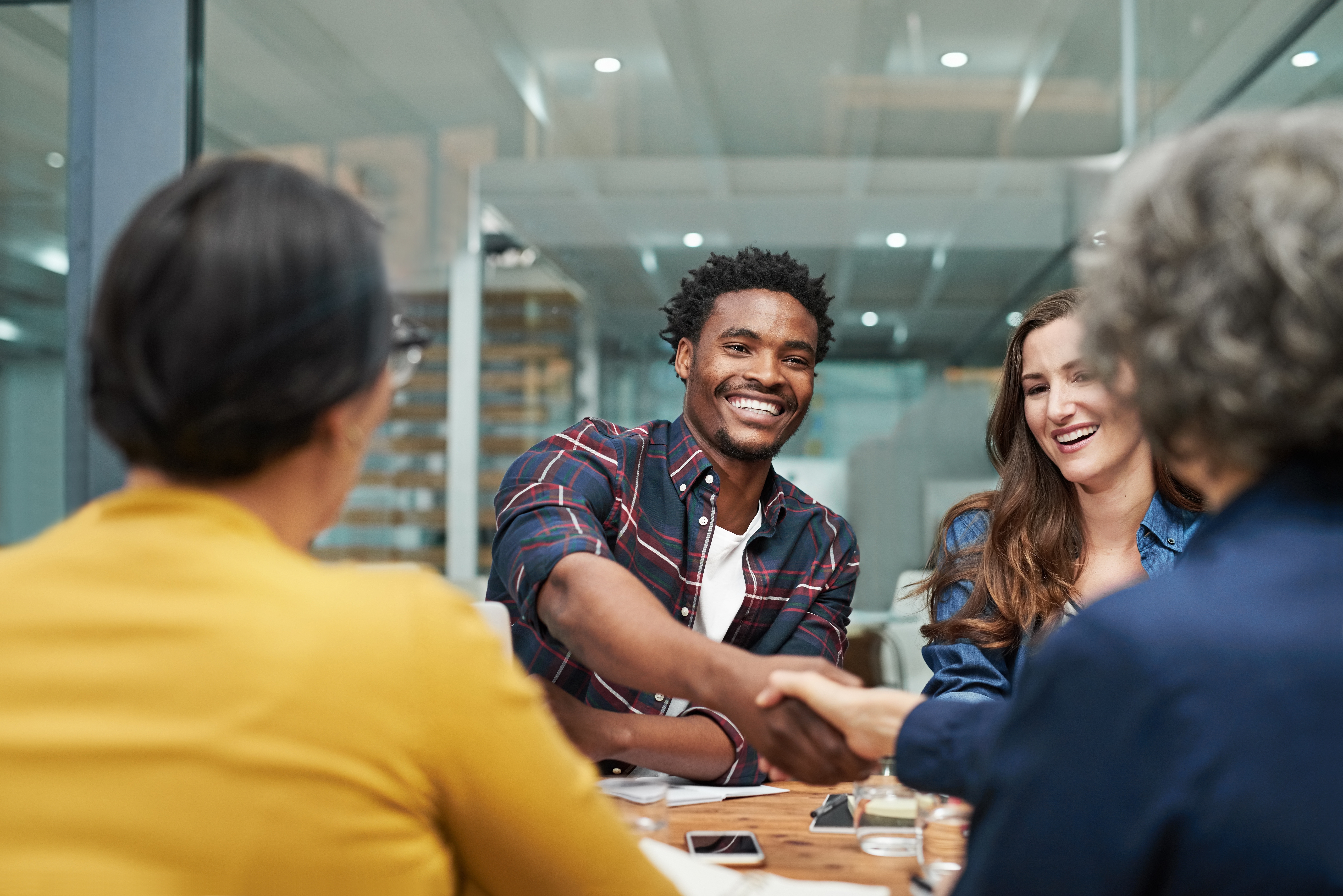 Students sitting around a table and talking to each other before an English class