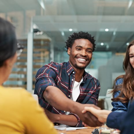 Students sitting around a table and talking to each other before an English class