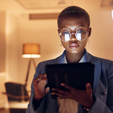 Woman holding a tablet and logging in to her online English class with Berlitz Edmonton