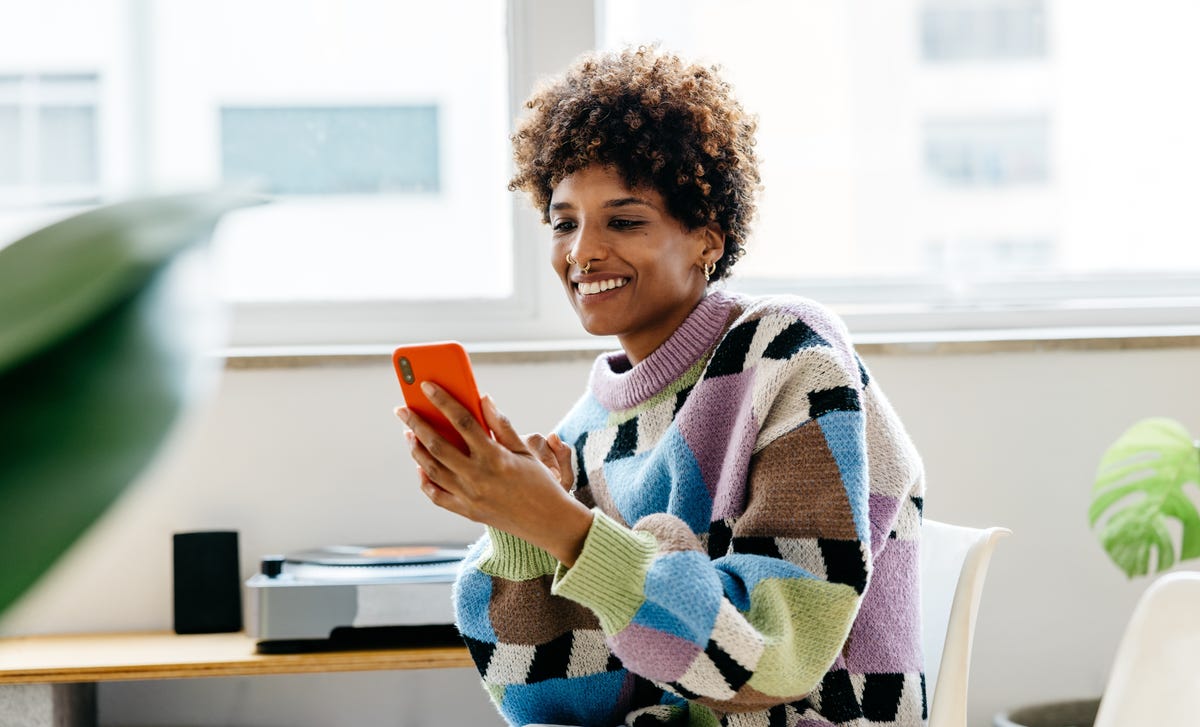 Woman in a sweater checking Berlitz Flex on her phone