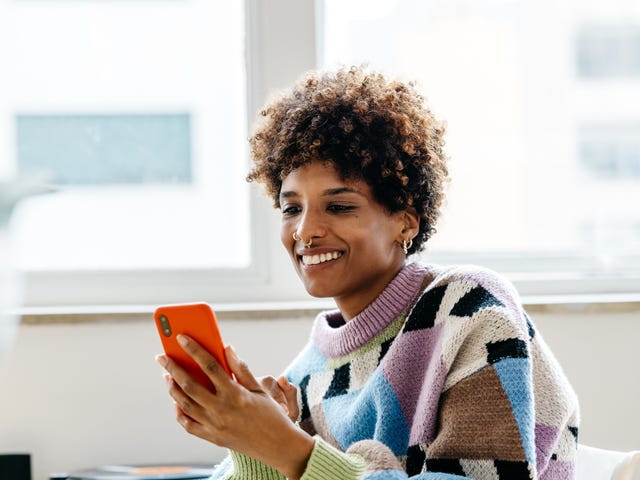 Woman in a sweater checking Berlitz Flex on her phone