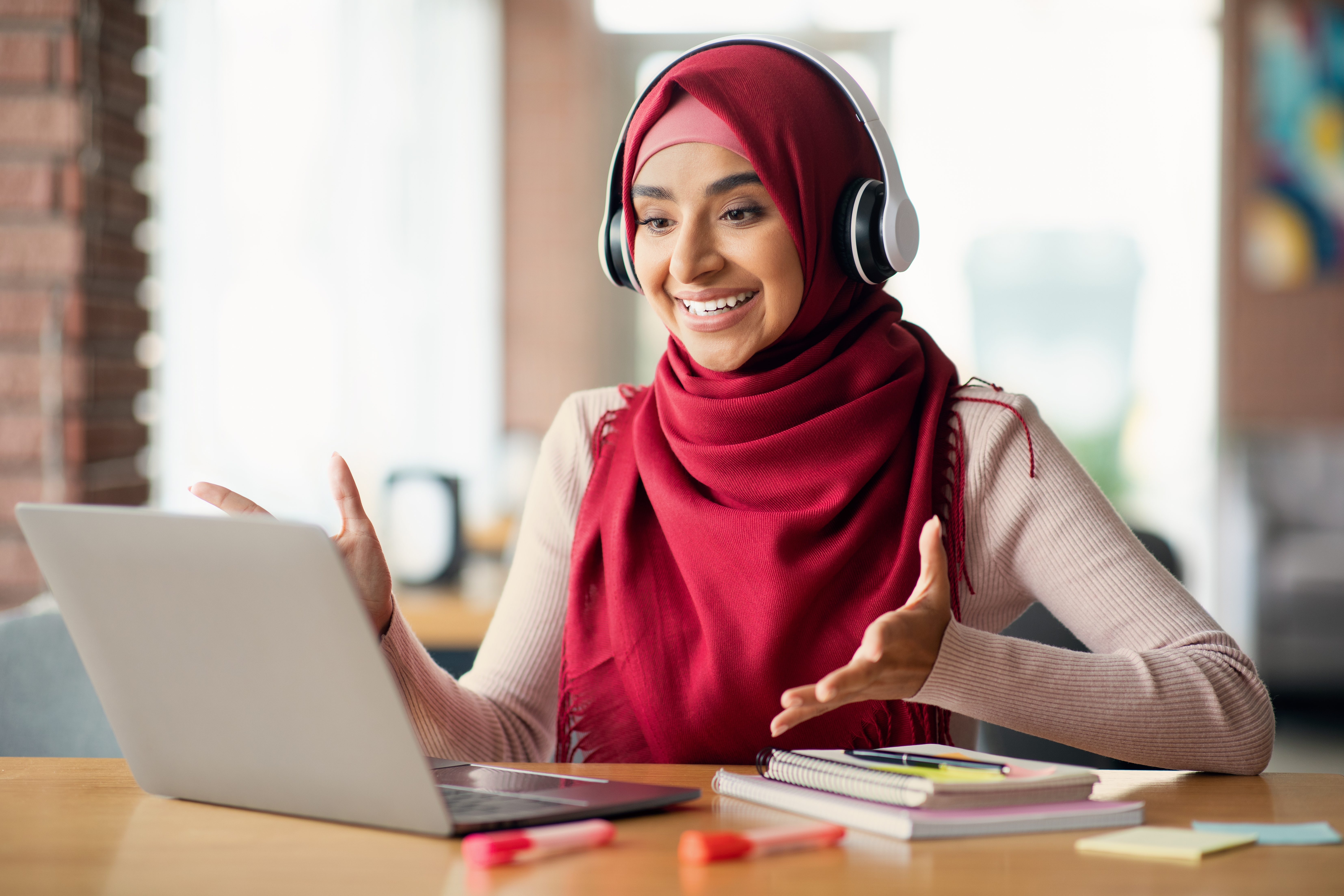Woman with headphones talking to her classmates during an online group language lesson with Berlitz Canada