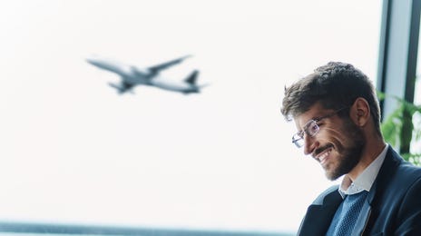 Man sitting at the airport and learning a language with Berlitz Flex between his flights