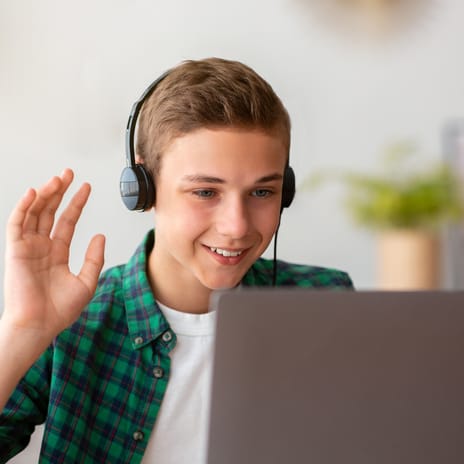 Boy waving hi at his instructor at the beginning of his private online language class for kids and teens with Berlitz