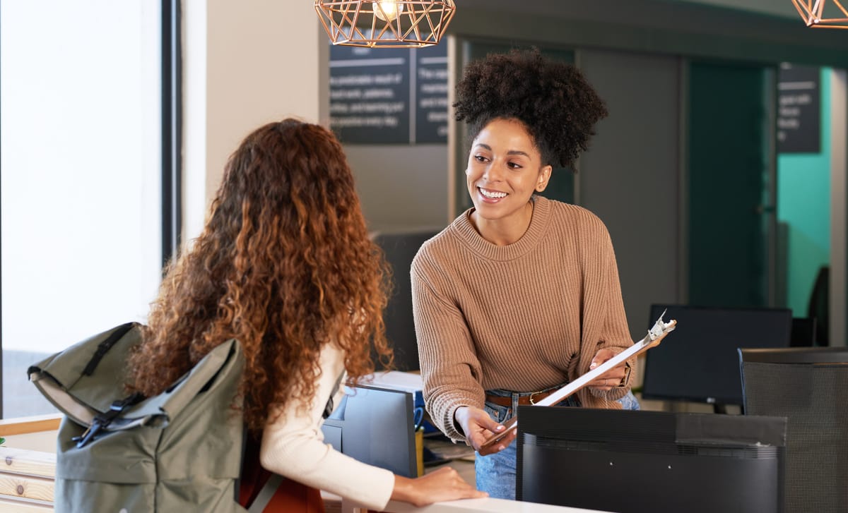 Woman helping another woman speaking French confidently in her federal job