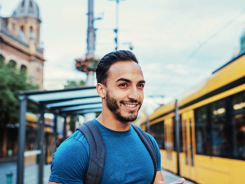 Man with a phone in his hand doing language exercises while waiting for the train