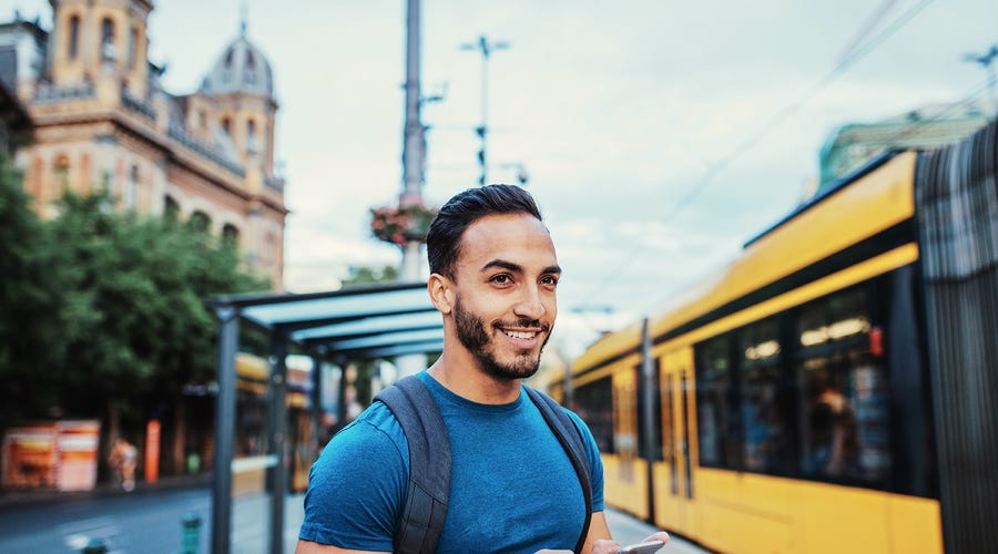 Man with a phone in his hand doing language exercises while waiting for the train