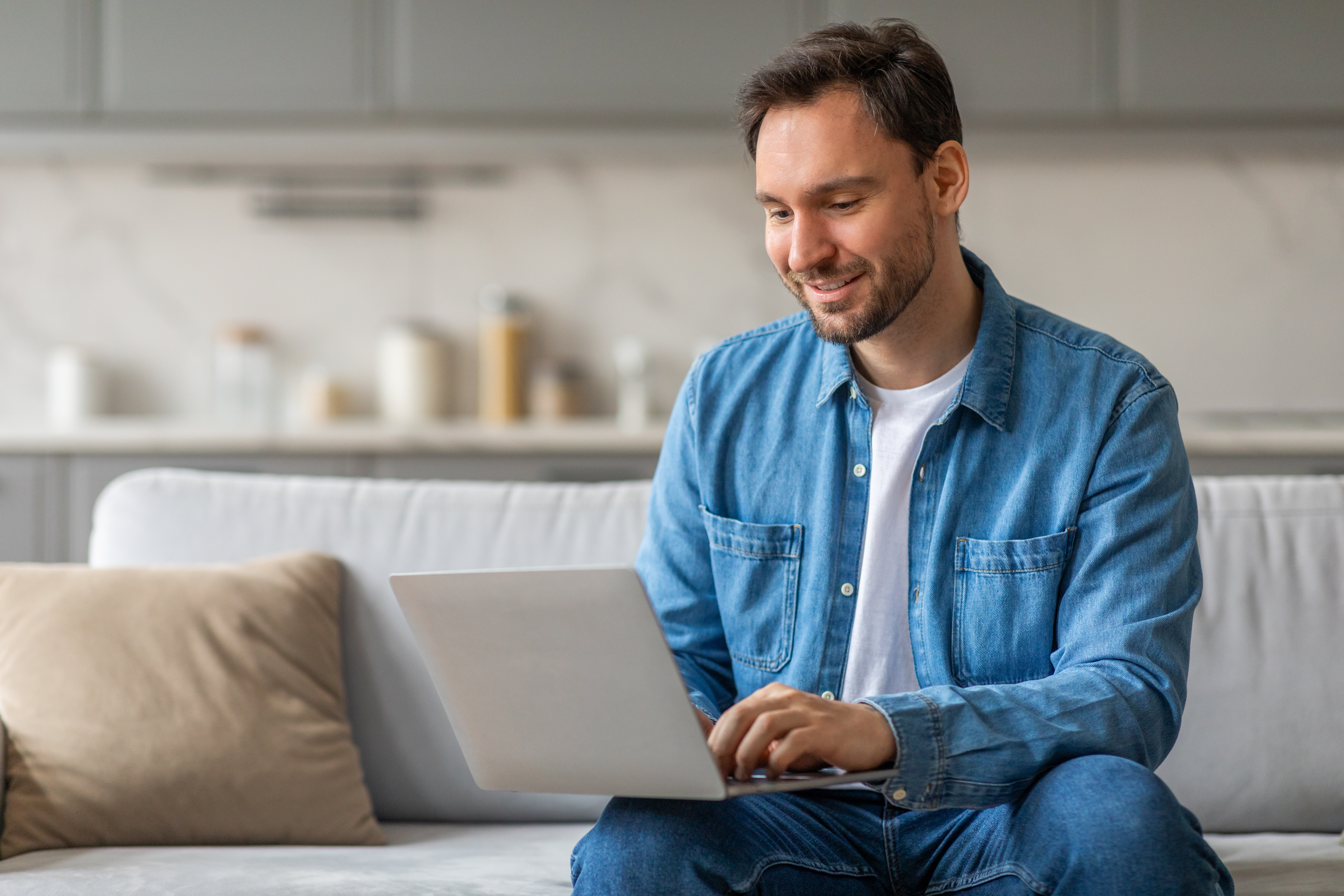 Man with a laptop attending an online French course with Berlitz from his living room