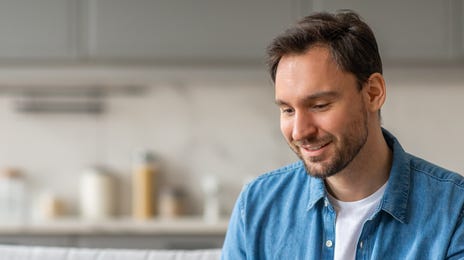Man with a laptop attending an online French course with Berlitz from his living room