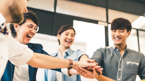 Student high fiving each other during a beginner English class at Berlitz Toronto
