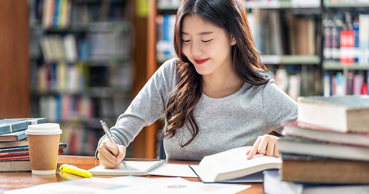 Woman in a library doing Spanish gender exercises
