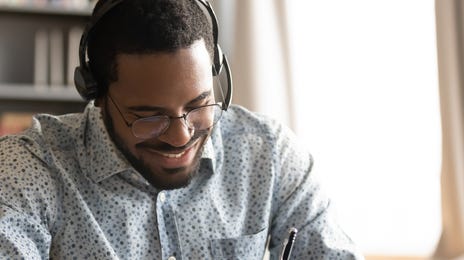 man learning french online at home on his computer