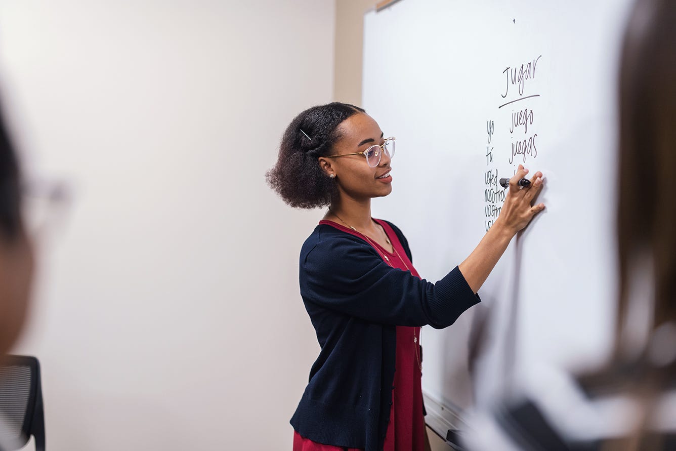 Woman writing on a whiteboard during her language lesson on her way to beome a polyglot