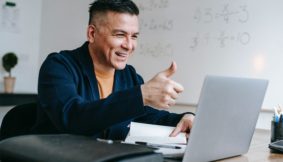 Man showing his thumbs signifying he likes something to people during an online meeting