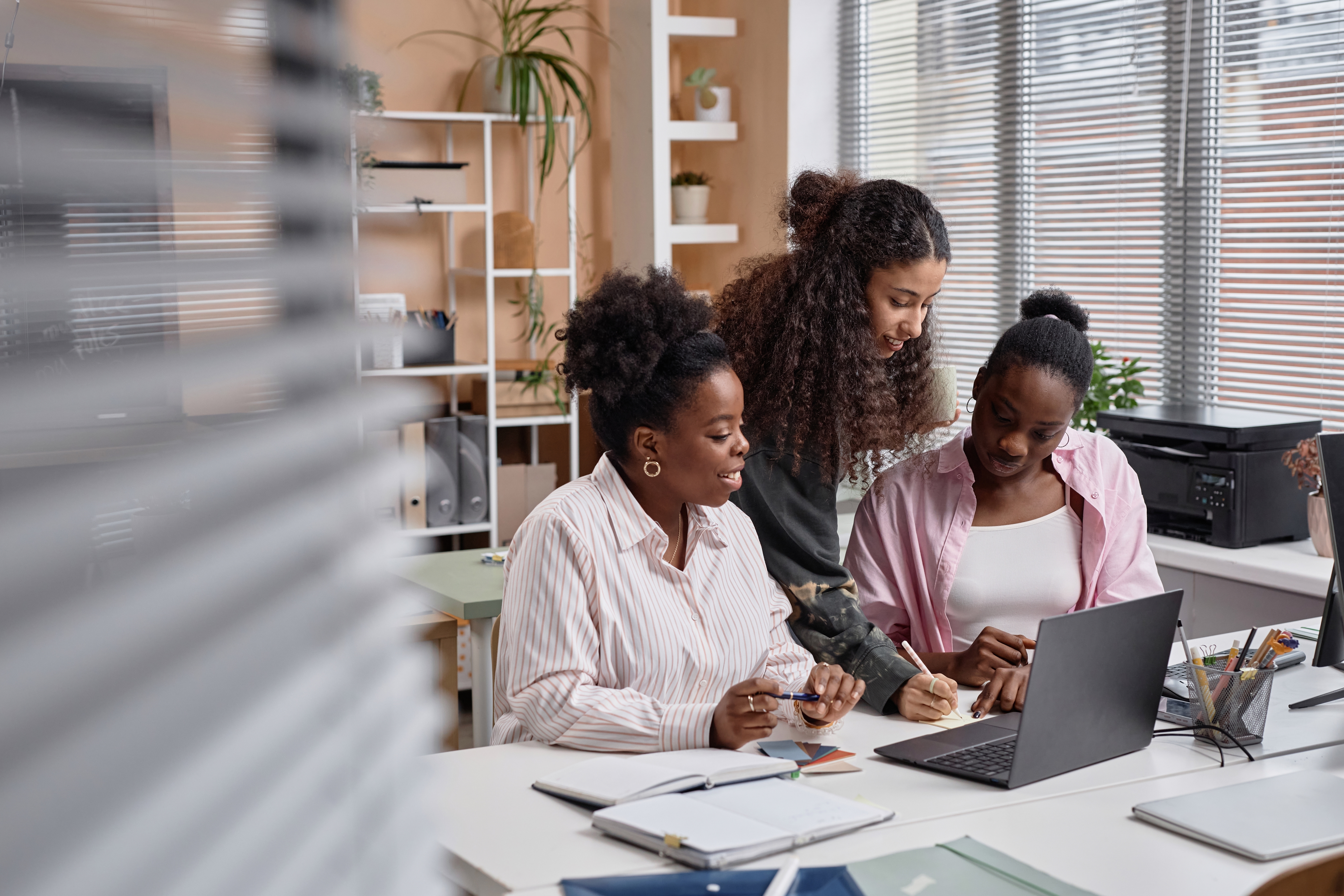 Women in the office making notes while using the Cultural Navigator to learn about cultures