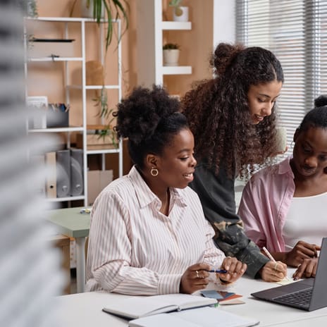 Women in the office making notes while using the Cultural Navigator to learn about cultures
