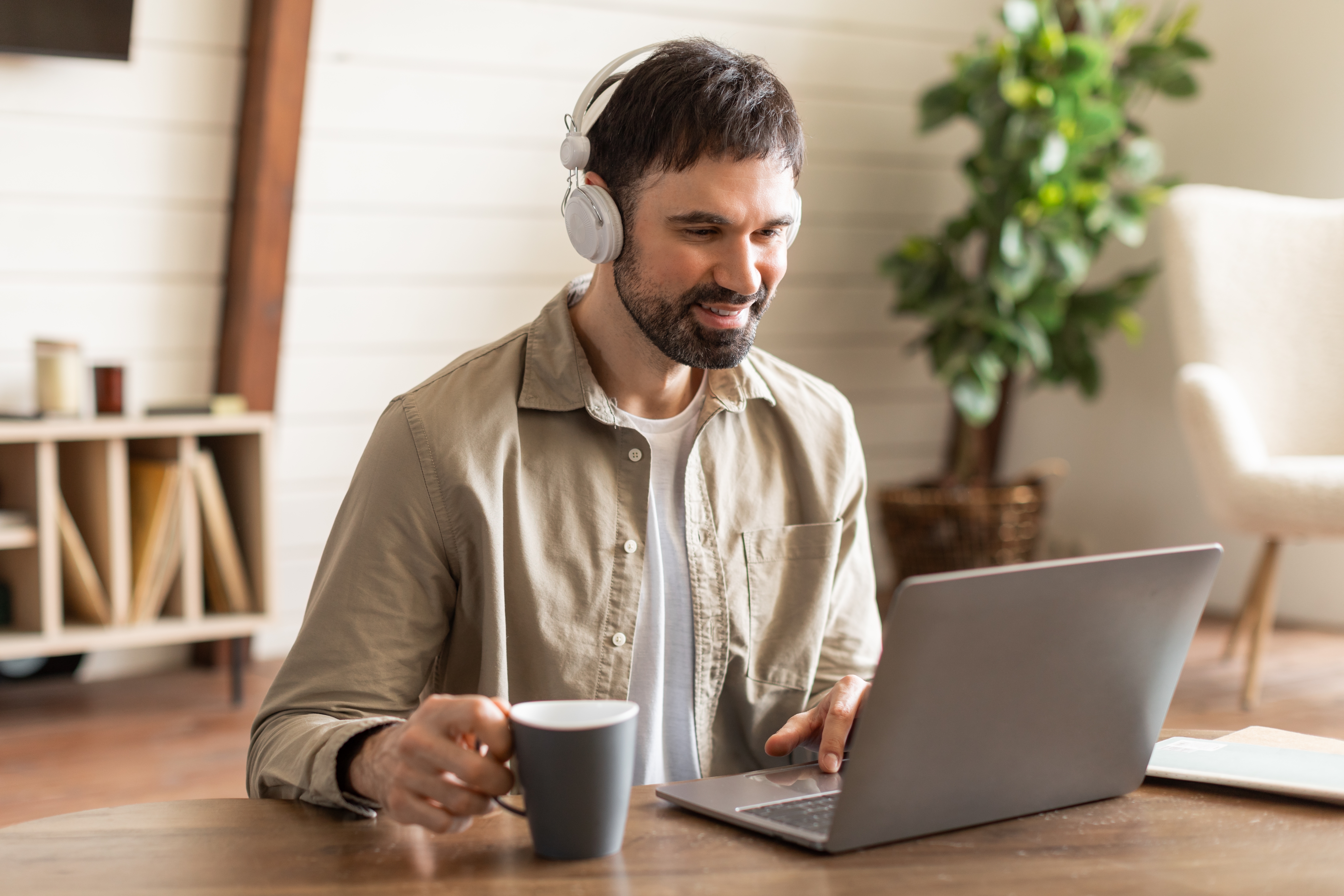 Man with a headphone attending an online Business English class with Berlitz Edmonton from his laptop