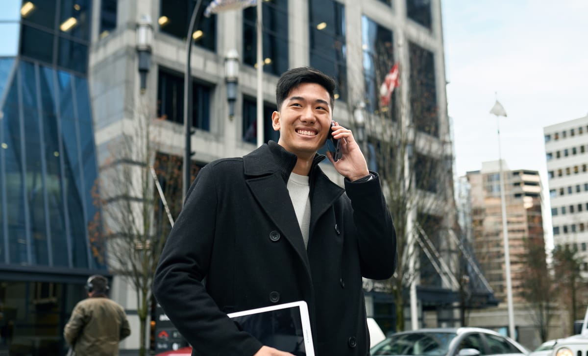 Man on the phone smiling happily after his French class with Berlitz Canada