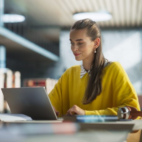 Government employee at work sitting in front of her laptop and learning a language with Berlitz's Cyberteachers