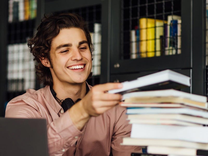 Man in a library checking books about gender in Spanish