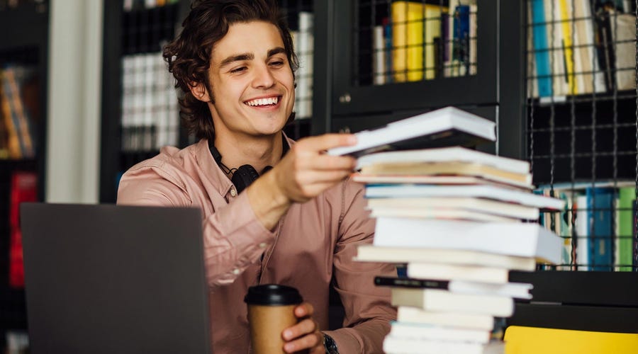 Man in a library checking books about gender in Spanish