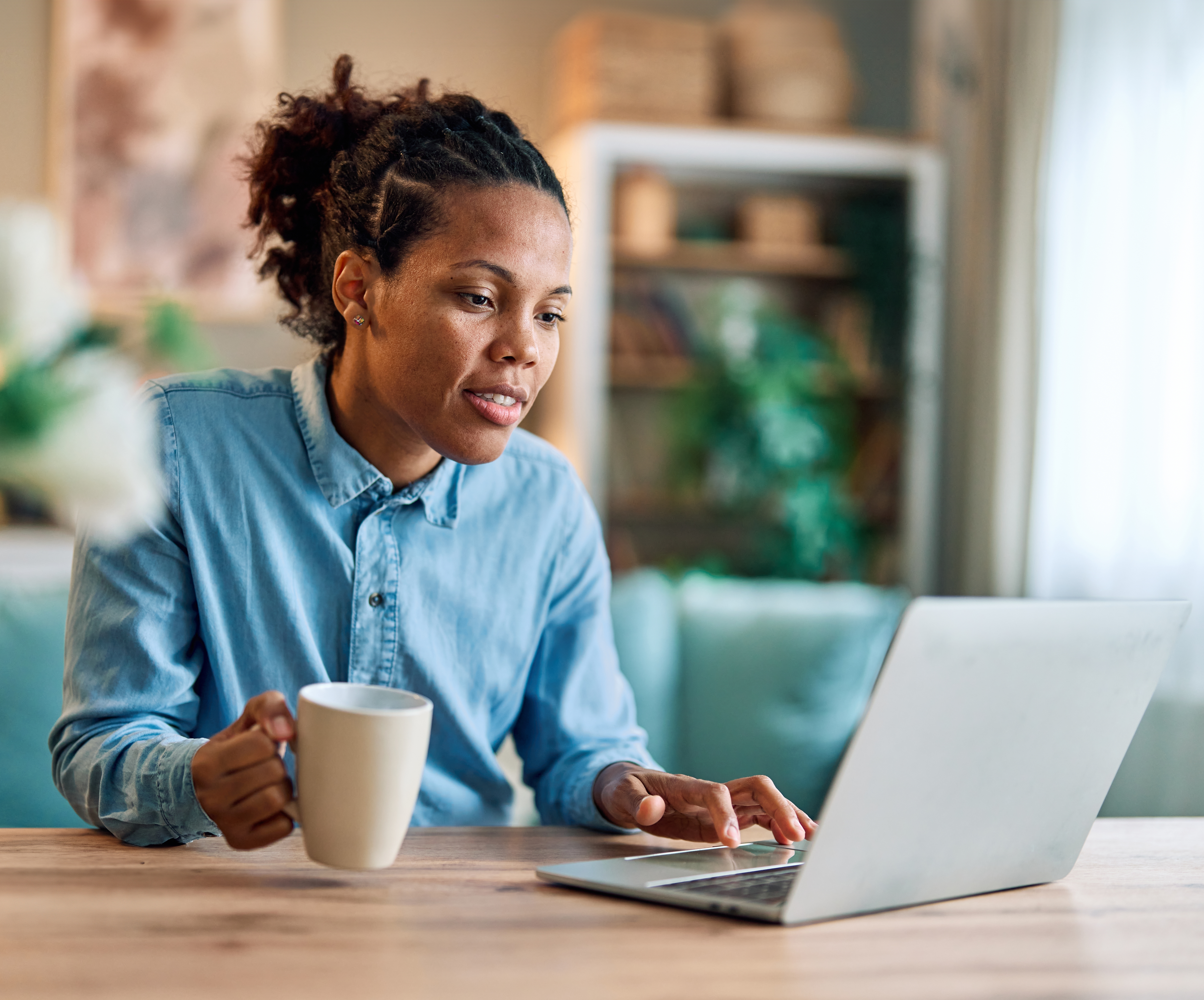 Woman in Edmonton attending an online Spanish lesson with Berlitz Canada from her laptop while drinking a cup of tea