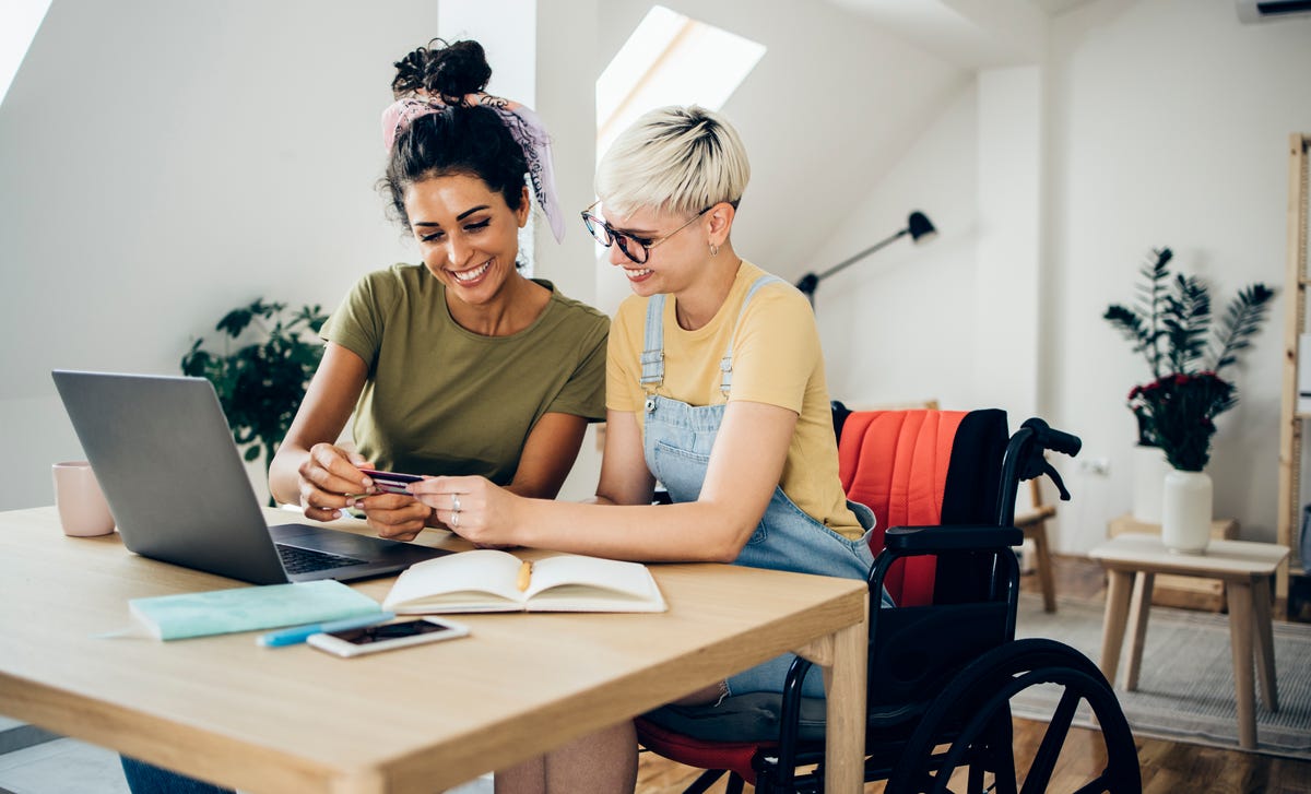 Two women in front of a laptop browsing English courses with Berlitz Toronto