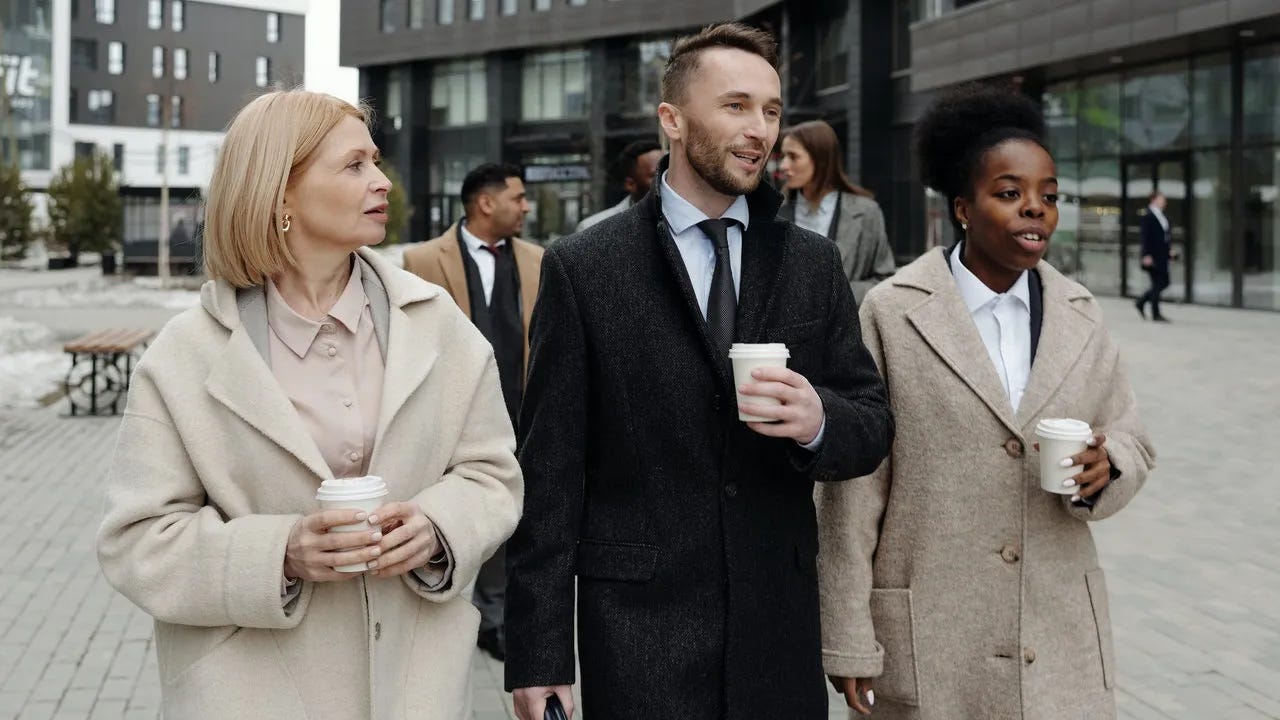 Coworkers_walking_and_having_coffee.webp